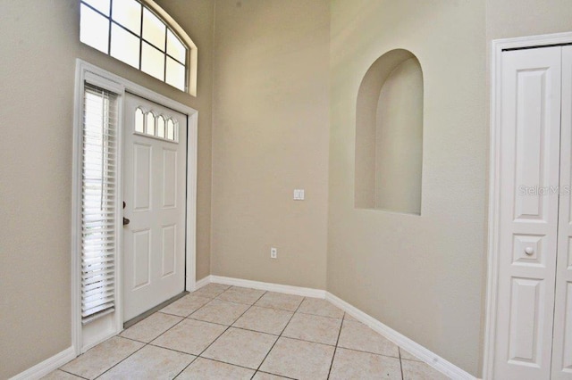 entryway featuring baseboards and light tile patterned flooring