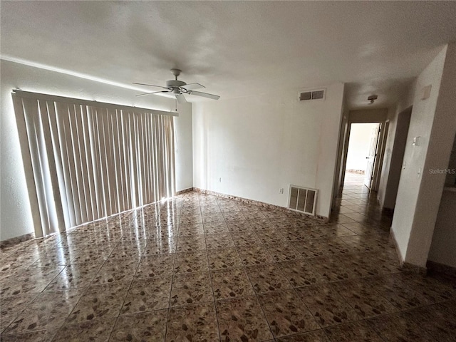 empty room with ceiling fan and a textured ceiling