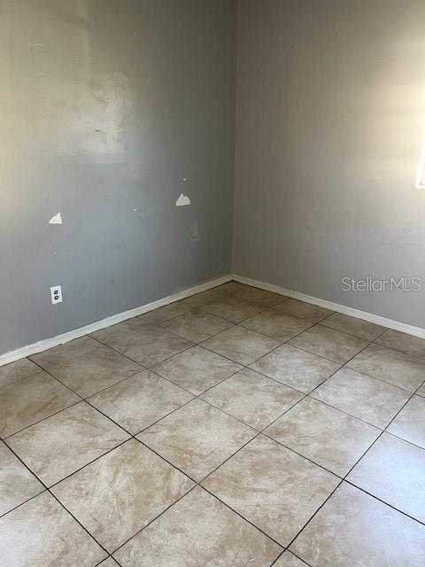 spare room featuring light tile patterned flooring