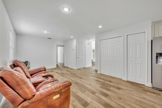 living room featuring light hardwood / wood-style flooring and a textured ceiling