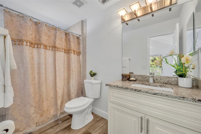 bathroom featuring hardwood / wood-style floors, vanity, a shower with shower curtain, and toilet