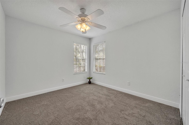 carpeted empty room featuring ceiling fan and a textured ceiling