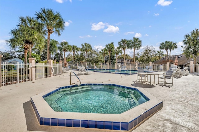 view of pool with a patio area and a hot tub