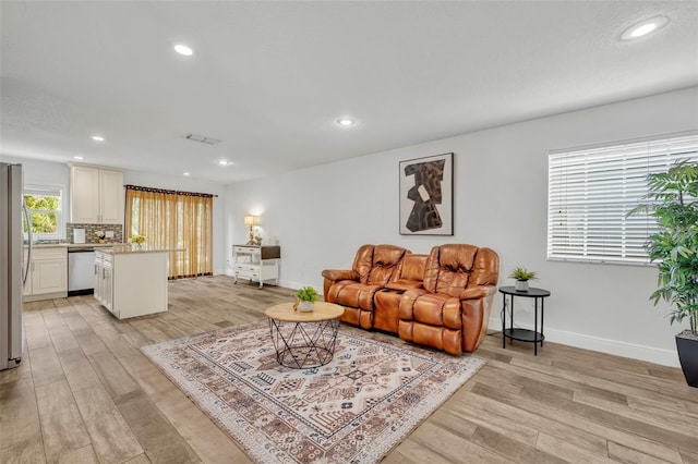 living area featuring light wood finished floors, visible vents, recessed lighting, and baseboards