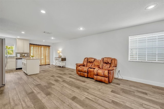 living area featuring light wood finished floors and recessed lighting