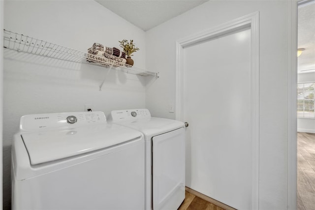 laundry area featuring laundry area, light wood-style flooring, and washing machine and clothes dryer