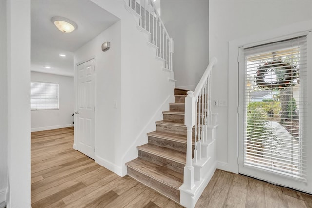 stairway featuring recessed lighting, wood finished floors, and baseboards