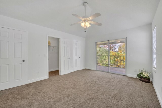 unfurnished bedroom featuring baseboards, carpet floors, access to exterior, and a ceiling fan