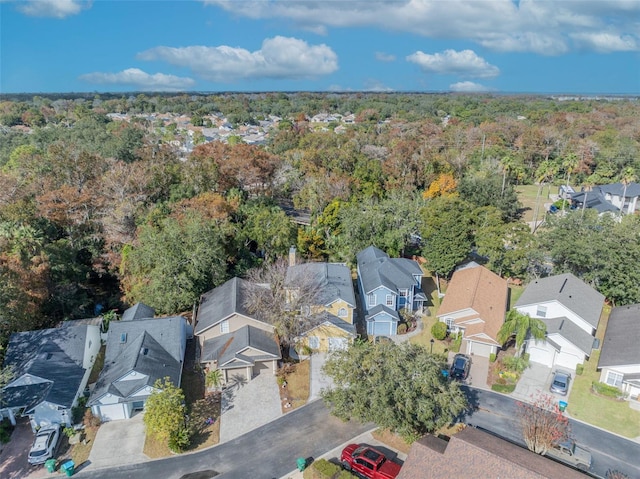 drone / aerial view featuring a forest view and a residential view