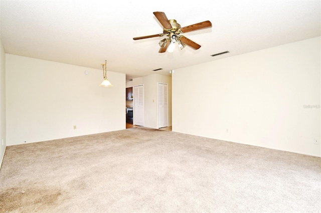 unfurnished room with ceiling fan and light colored carpet