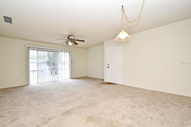 unfurnished room with carpet flooring, ceiling fan, and a textured ceiling