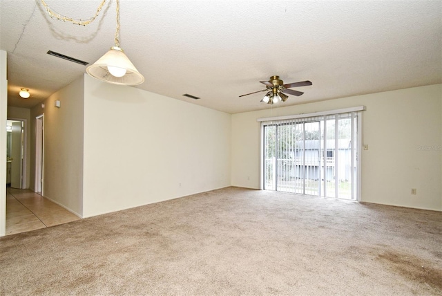 carpeted spare room with ceiling fan and a textured ceiling