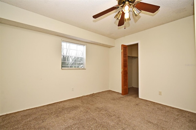 carpeted empty room featuring a textured ceiling and ceiling fan