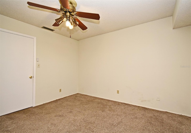 carpeted empty room with ceiling fan and a textured ceiling