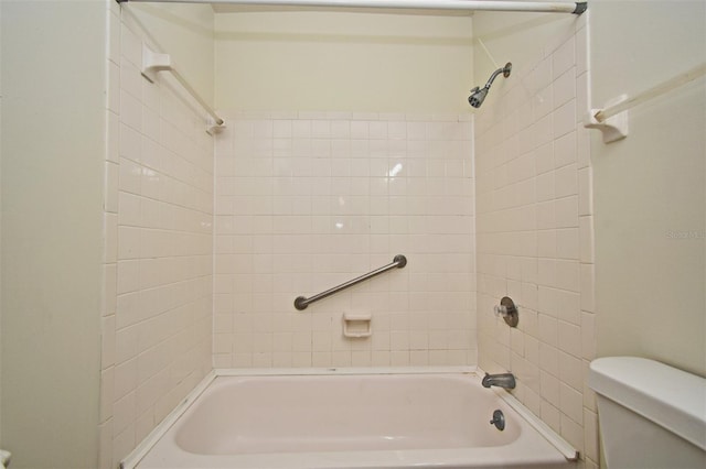 bathroom featuring toilet and tiled shower / bath