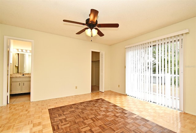 empty room with ceiling fan, a textured ceiling, and light parquet flooring