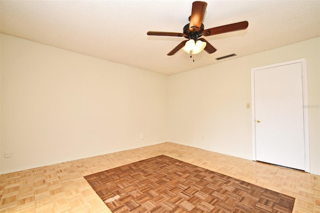 empty room with ceiling fan, parquet floors, and a textured ceiling