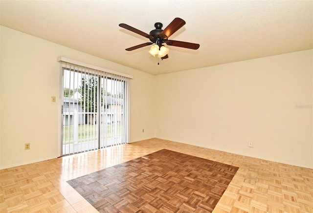 empty room with ceiling fan, a textured ceiling, and light parquet floors