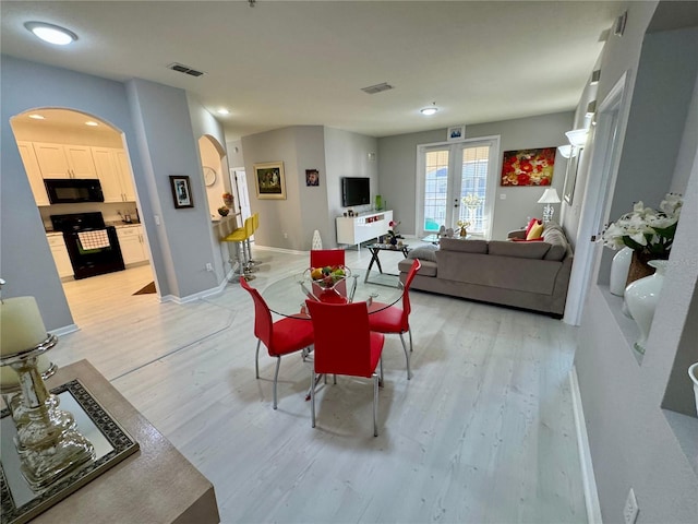 dining space with light hardwood / wood-style floors and french doors