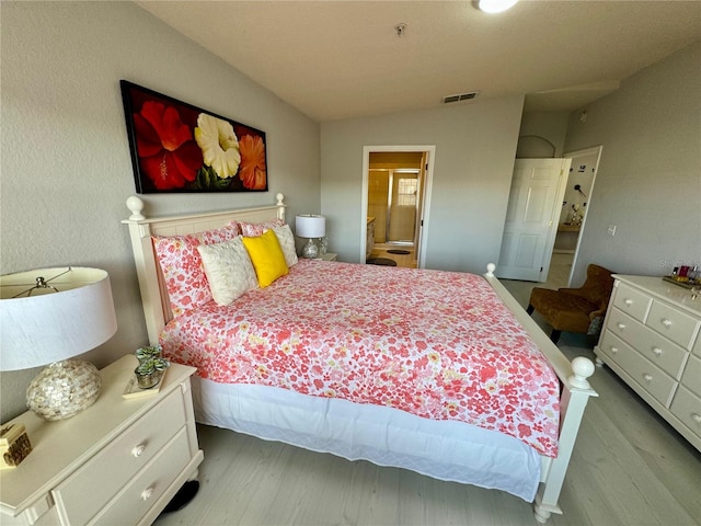 bedroom with lofted ceiling and light wood-type flooring