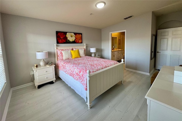 bedroom with light hardwood / wood-style floors and connected bathroom