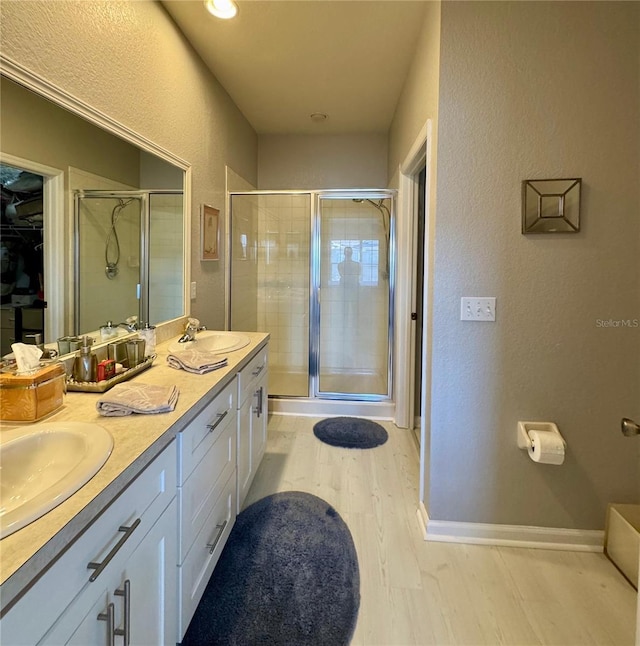 bathroom featuring wood-type flooring, vanity, and a shower with door