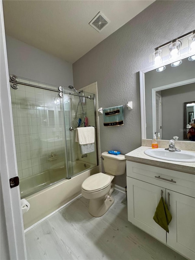 full bathroom with toilet, vanity, enclosed tub / shower combo, and hardwood / wood-style flooring