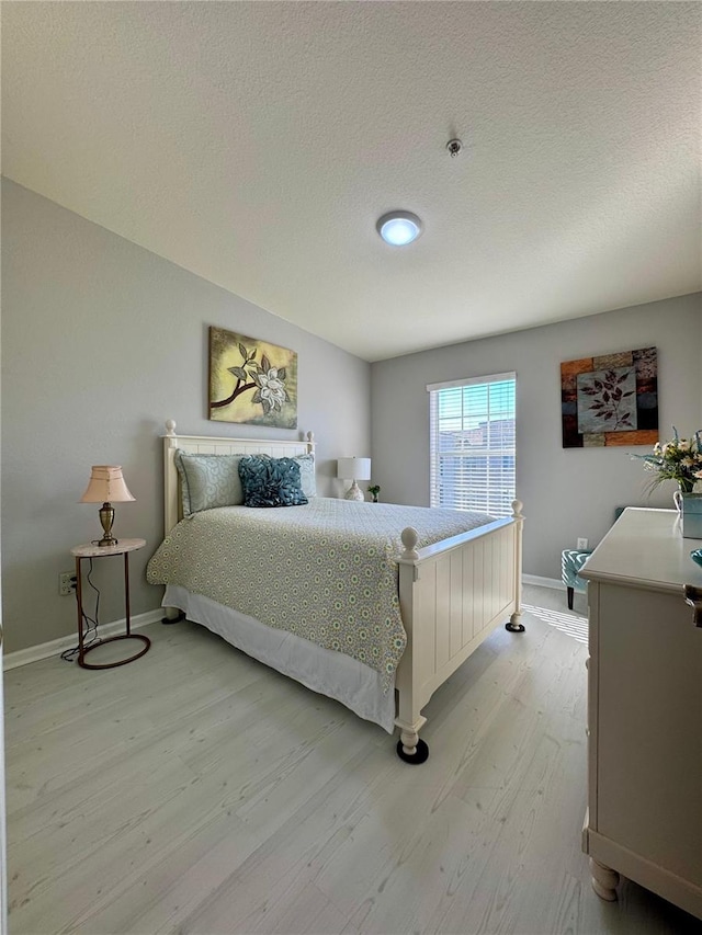 bedroom featuring a textured ceiling and light wood-type flooring