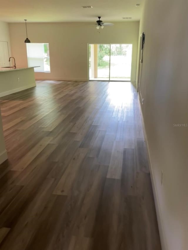 unfurnished room with dark hardwood / wood-style flooring, ceiling fan, and sink