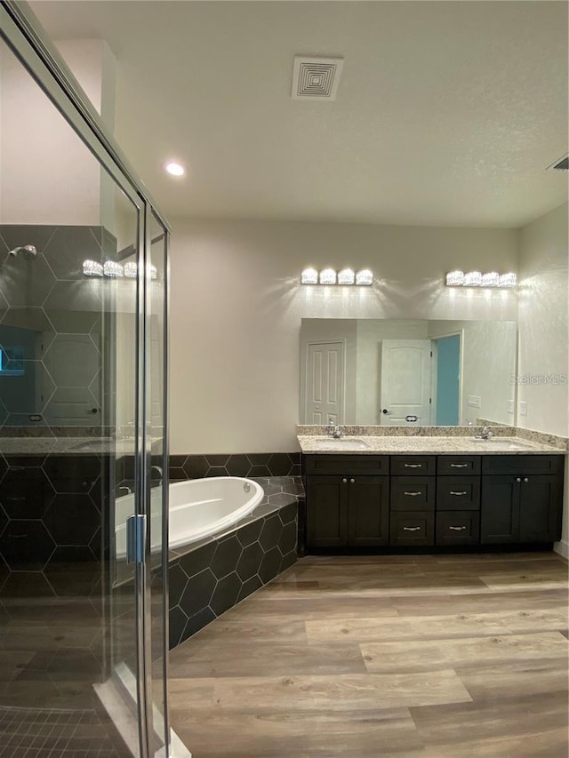 bathroom featuring hardwood / wood-style floors, vanity, and independent shower and bath