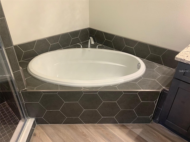 bathroom featuring hardwood / wood-style floors, vanity, and separate shower and tub