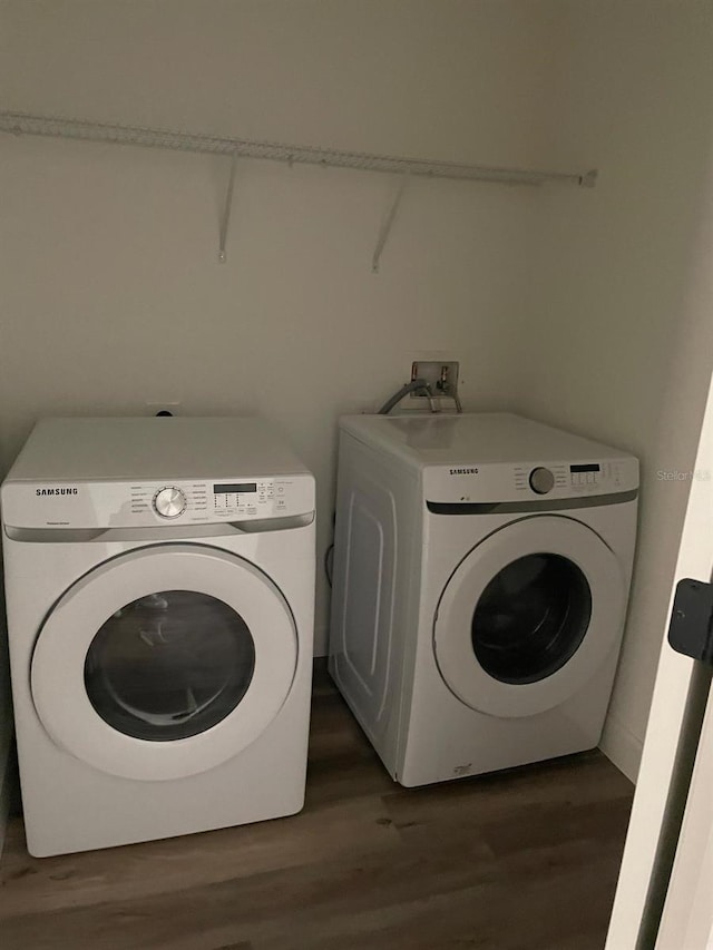 clothes washing area featuring separate washer and dryer and dark hardwood / wood-style floors