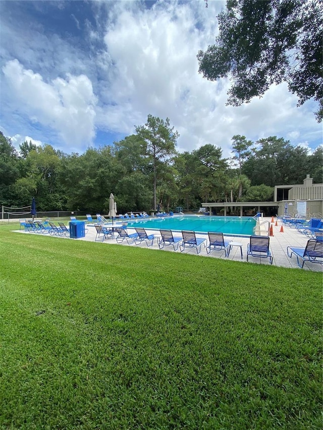 view of pool featuring a yard and a patio