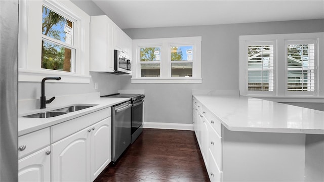 kitchen featuring dark wood-type flooring, sink, white cabinetry, kitchen peninsula, and stainless steel appliances