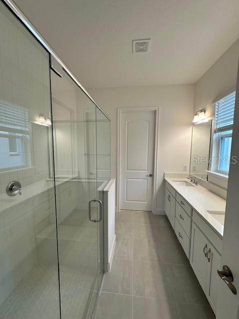 bathroom featuring vanity, tile patterned flooring, and a shower with door