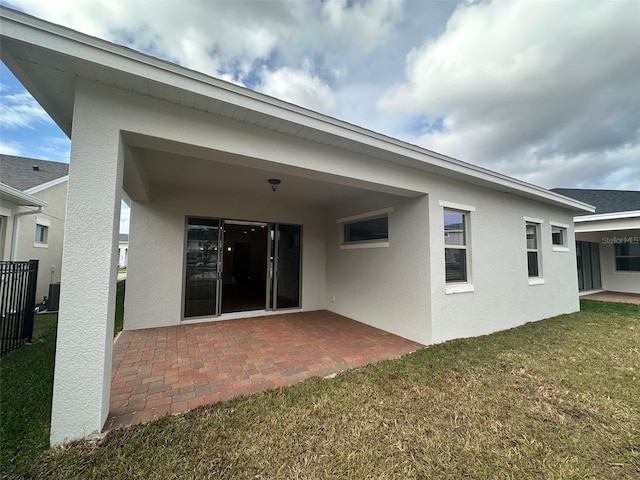 rear view of property featuring a lawn and a patio