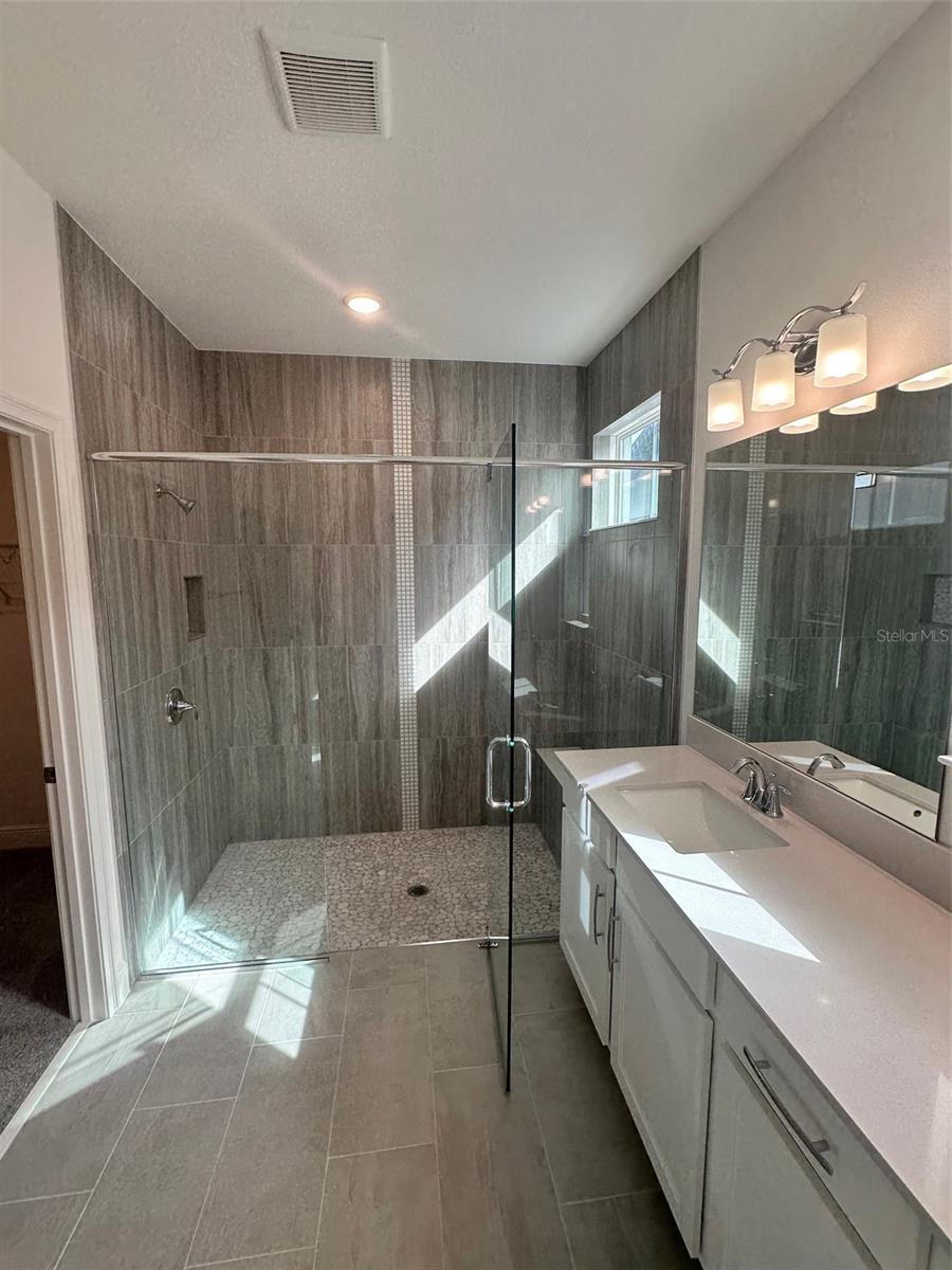 bathroom with vanity, a shower with shower door, and tile patterned flooring