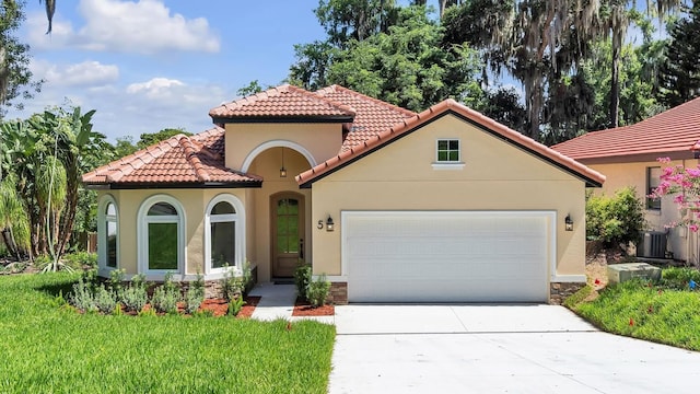 mediterranean / spanish-style house featuring a garage and cooling unit