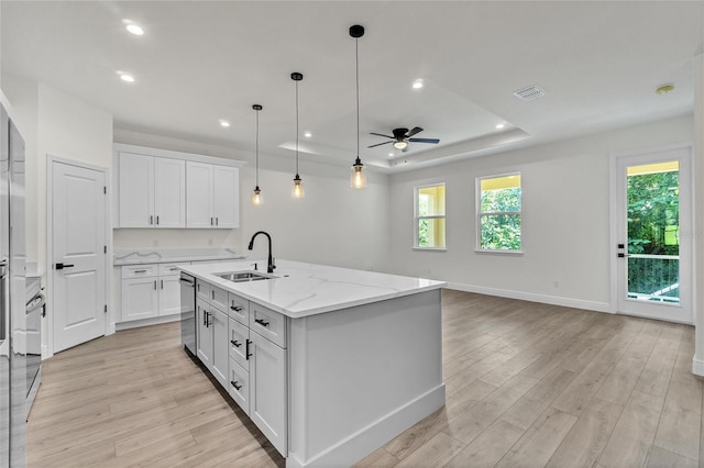 kitchen featuring ceiling fan, sink, a center island with sink, dishwasher, and white cabinetry