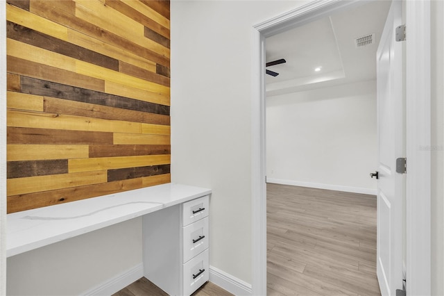 bathroom featuring wood-type flooring, a raised ceiling, and ceiling fan