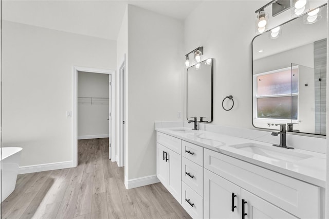 bathroom with a bathing tub, vanity, and wood-type flooring