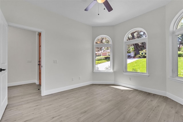 spare room with ceiling fan, light hardwood / wood-style flooring, and a healthy amount of sunlight