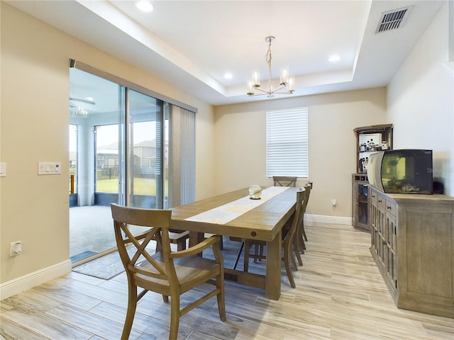 dining area featuring a notable chandelier and a tray ceiling