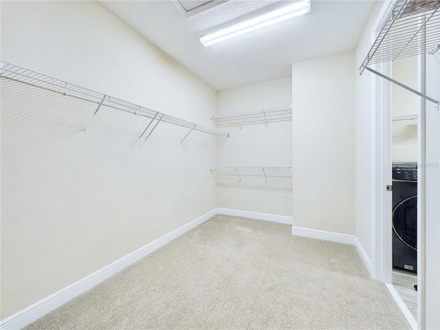 walk in closet with light carpet and washer / clothes dryer