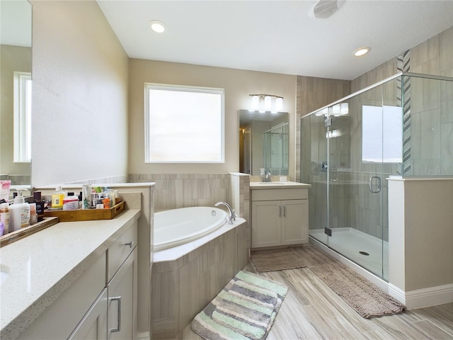 bathroom with shower with separate bathtub and vanity