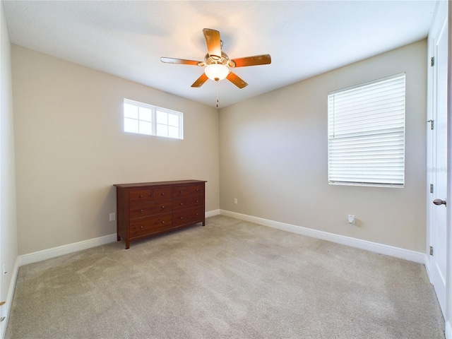 carpeted spare room with ceiling fan