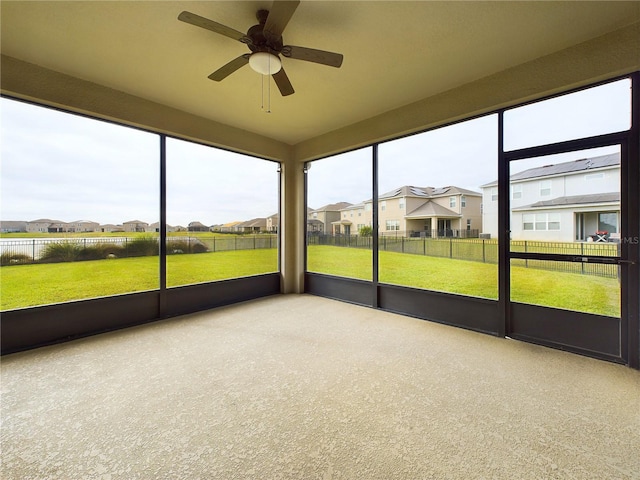 unfurnished sunroom with ceiling fan