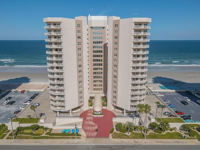 view of property with a view of the beach and a water view