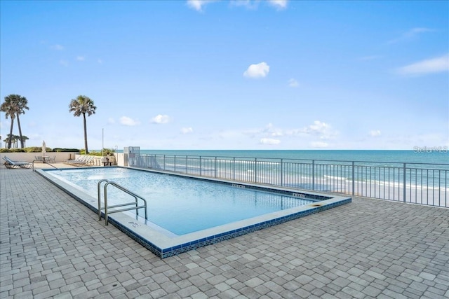 view of swimming pool with a water view and a patio area