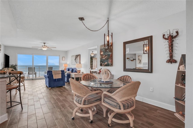 dining room with ceiling fan, dark wood-type flooring, and a textured ceiling